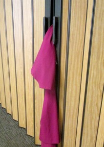 Choir robe futilely tries to escape from closet.